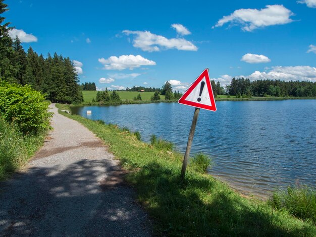 Road sign at the edge of the pond koegel in summer with a blue sky and small white clouds