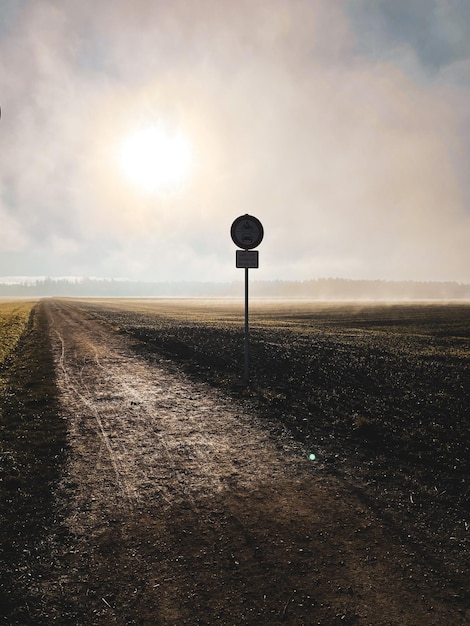 Photo road sign on field against sky during sunset