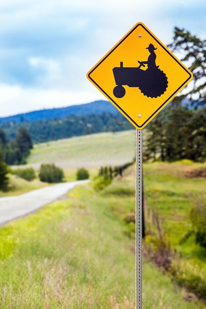 Road sign on field against sky