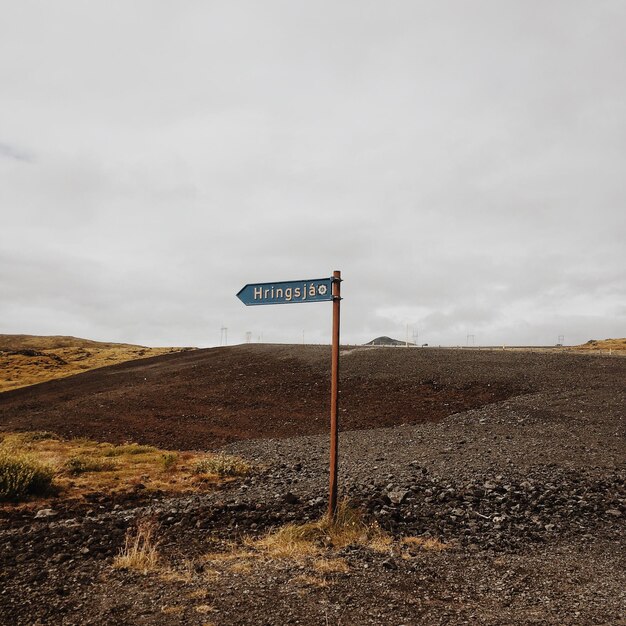 Photo road sign on field against sky