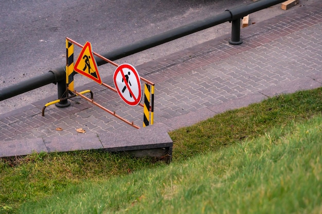 A road sign installed on the sidewalk and prohibits the\
movement of pedestrians due to an accident or road works\
prohibition of traffic on the sidewalk