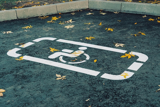 Дорожный знак-парковка для инвалидов, нарисованный белыми линиями на асфальте