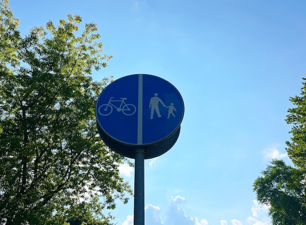 Segnale stradale pista pedonale e ciclabile con separazione del traffico sullo sfondo del cielo blu