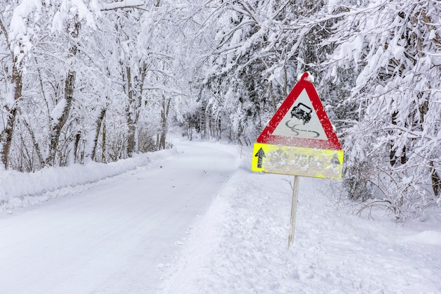 Photo road sign warns of ice and snow at winter