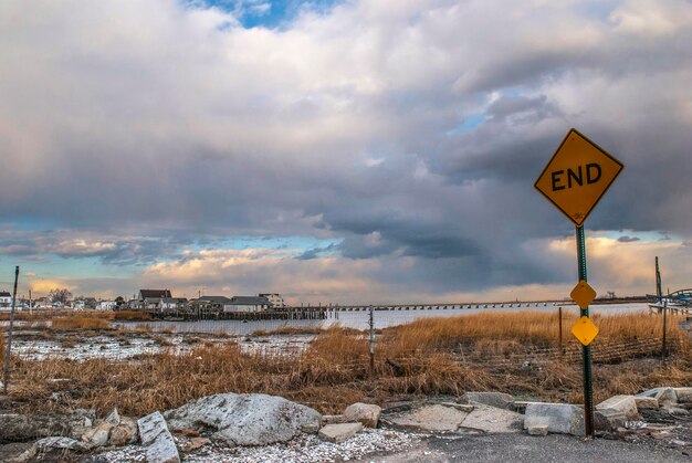 Road signs on field against sky during sunset