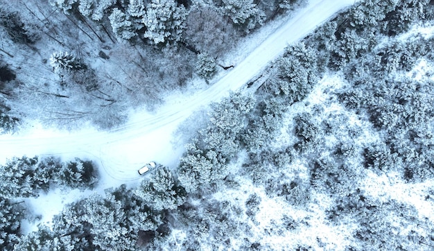 road in the snow with a house in the background