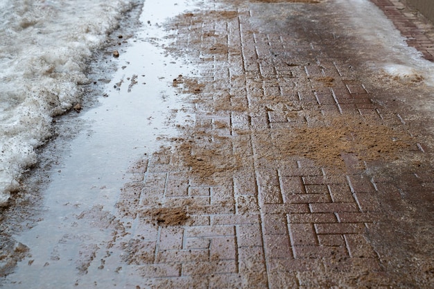 Road surface treated with technical salt and sand to prevent ice formation salt puddles on the road