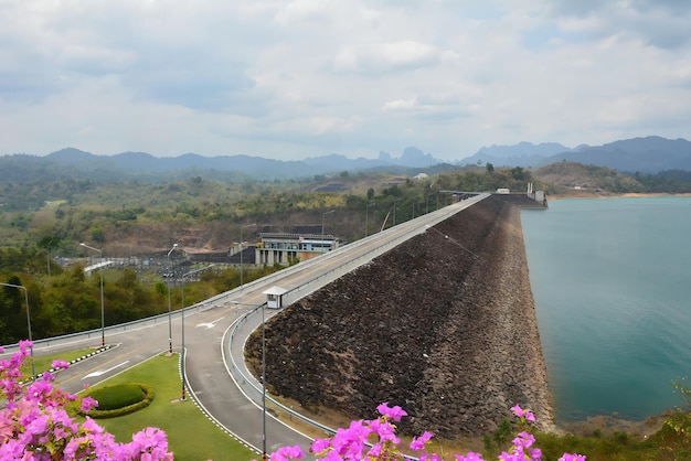 A road that is next to a lake with mountains in the background