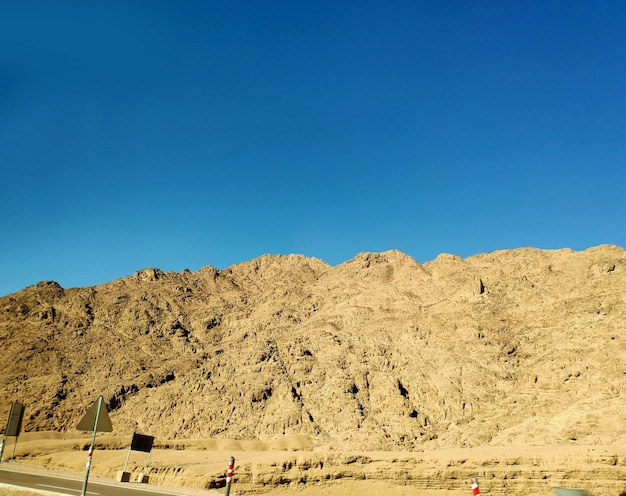 사막을 가로지르는 길 산과 언덕과 함께 그림 같은 배경 사막 풍경 벽지