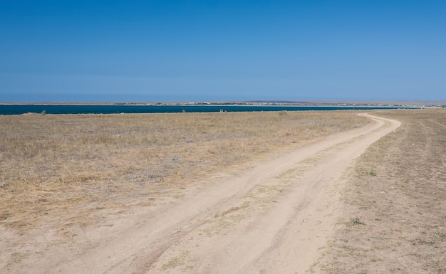 Road through the field next to sea