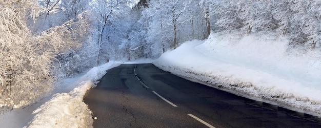 Road through a forest with trees covered with frost in alpine mountain