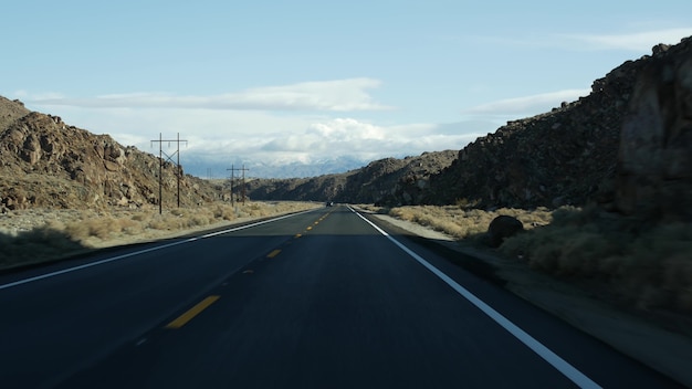 アメリカ、カリフォルニアで自動車を運転するデスバレーへのロードトリップ。アメリカを旅するヒッチハイク。高速道路、山、乾燥した砂漠、乾燥した気候の荒野。車からの乗客のPOV。ネバダへの旅。