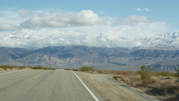 Road trip to death valley, driving auto in california, usa.
hitchhiking traveling in america. highway, mountains and dry
desert, arid climate wilderness. passenger pov from car. journey to
nevada.