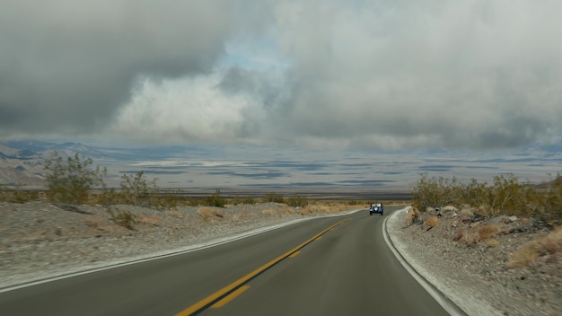 アメリカ、カリフォルニアで自動車を運転するデスバレーへのロードトリップ。アメリカを旅するヒッチハイク。高速道路、山、乾燥した砂漠、乾燥した気候の荒野。車からの乗客のPOV。ネバダへの旅。