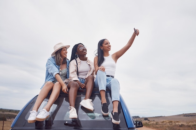 Road trip selfie of women friends on car roof with sky mockup for social media group travel and vacation Profile picture of diversity youth or people in Africa safari desert or countryside journey