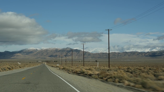 アメリカ、カリフォルニアで自動車を運転するデスバレーへのロードトリップ。アメリカを旅するヒッチハイク。高速道路、山、乾燥した砂漠、乾燥した気候の荒野。車からの乗客のpov。ネバダへの旅。