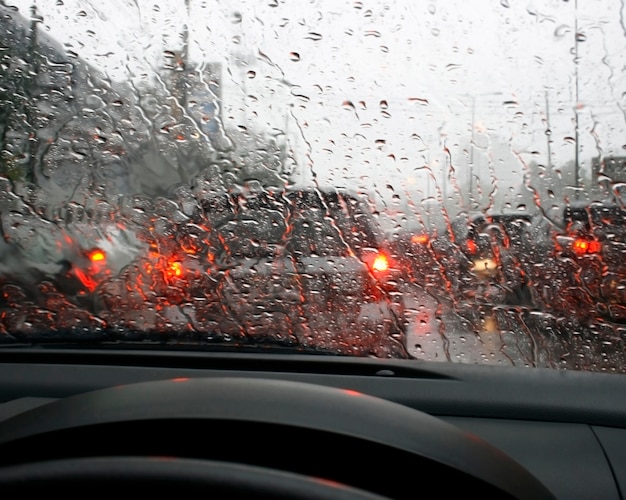 Road view through car window with rain drops