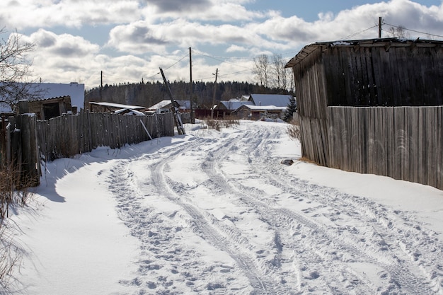 Road in the village covered with snow with traces of car tires. High quality photo