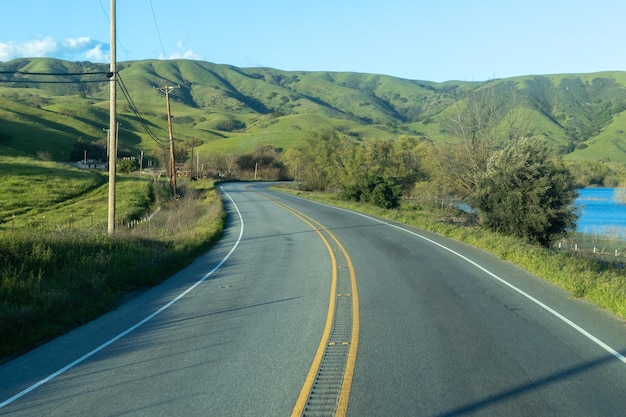 A road with green hills and a yellow line that says highway 101