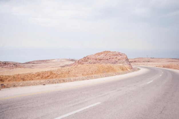 Photo a road with a large rock on the side of it