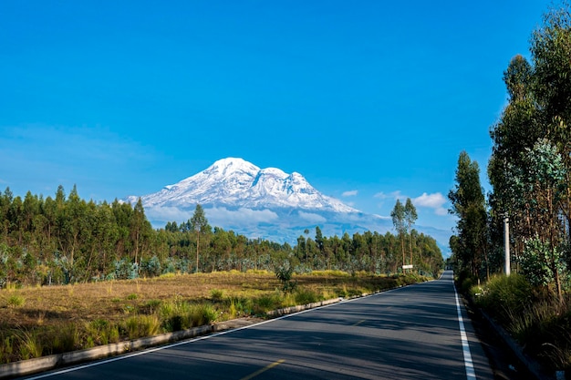 Foto una strada con una montagna sullo sfondo