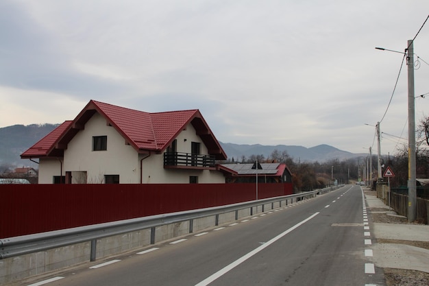 Photo a road with a red building and a red bridge with mountains in the background