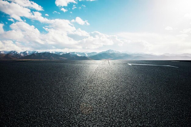 A road with tire tracks on it and the sky is blue background natural background