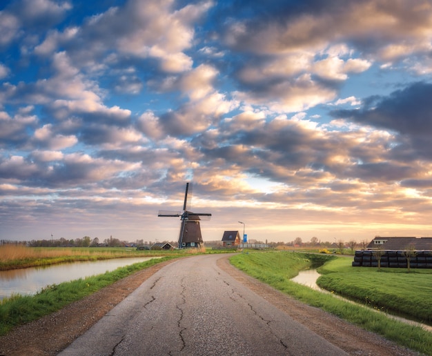 Road with windmill at sunrise in netherlands