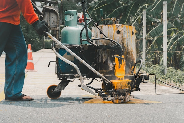 Road worker paint traffic lines on asphalt road surface