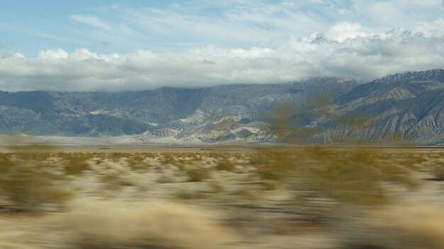 Roadtrip naar Death Valley, autorijden in Californië, VS. Liftend op reis in Amerika. Snelweg, bergen en droge woestijn, dorre klimaatwildernis. Passagier POV van auto. Reis naar Nevada.