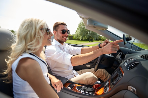 roadtrip, vrije tijd, reizen, technologie en mensenconcept - gelukkige man en vrouw die auto rijden en gps-navigatiesysteem gebruiken