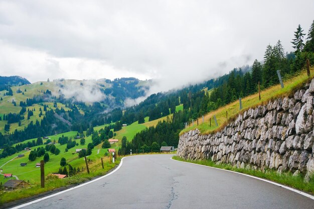 Roadway in the village of Boltigen with Swiss Alps at Jaun Pass in Fribourg canton in Switzerland.