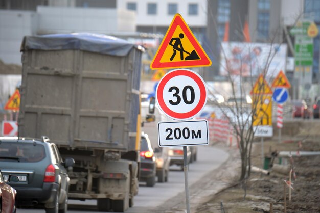 街路やゆっくりと移動する車の建設工事の交通標識を警告する道路工事