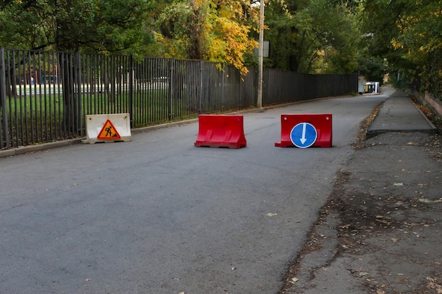 Roadworks warning traffic signs of construction work on city\
street and slowly moving cars