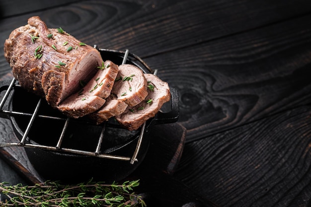 Roast beef on a grill tenderloin sliced meat with herbs Black Wooden background Top view Copy space