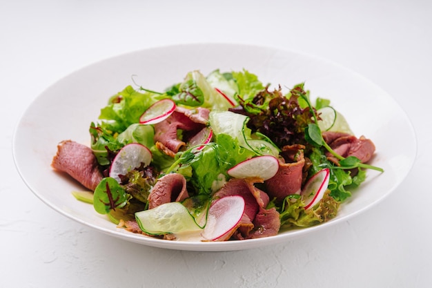 Roast beef salad with green mix on plate