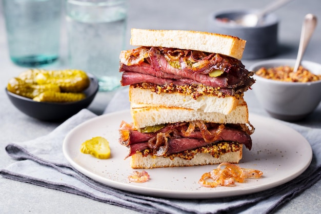 Foto sandwich di manzo arrosto su un piatto con sottaceti