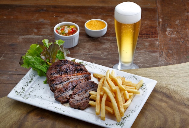 Roast beef with potatoes and salad and a glass of beer