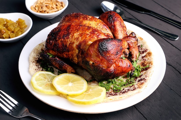 Photo roast chicken on black wooden background