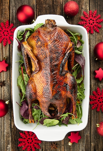 Roast goose stuffed with baked apples in a skillet on a dark wooden background festive christmas