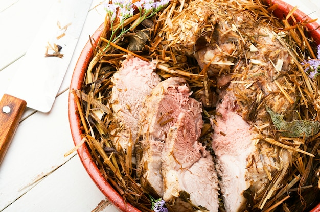 Roast pork in hay with herbs