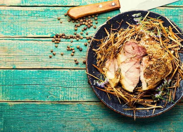 Roast pork in hay with herbs