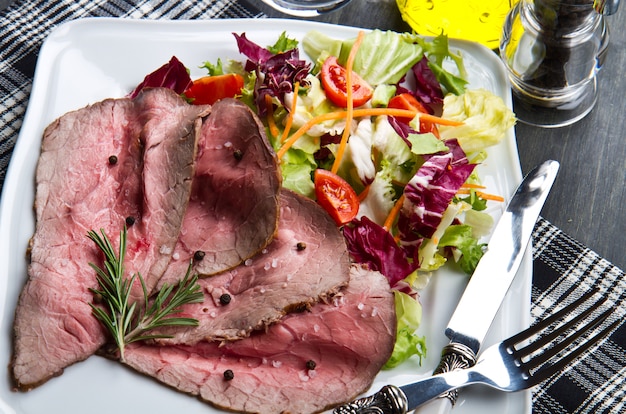 Foto roastbeef op witte schotel met salade