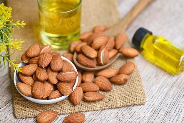 Roasted almond nut for healthy food and snack organic vegetable oils for cooking or spa concept Almond oil and Almonds nuts on bowl Delicious sweet almonds oil in glass bottle