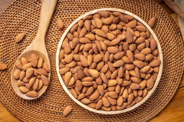 Roasted Almond on wooden table, Almond in wooden plate ready to serve.