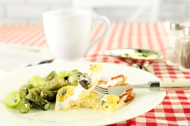 Roasted asparagus with fried egg on plate on table background