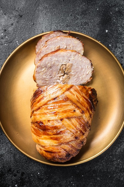 Roasted bacon wrapped meatloaf sliced mince meat loaf Black background Top view