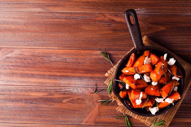 Roasted, baked pumpkin with addition aromatic herbs and goat cheese