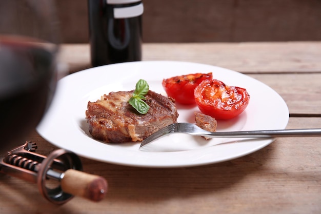 Roasted beef fillet on plate on wooden background