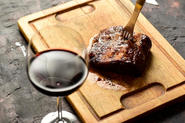 Roasted beef ribs with a glass of red wine presented on the table traditional Argentine cuisine Asado barbecue Patagonia Argentina